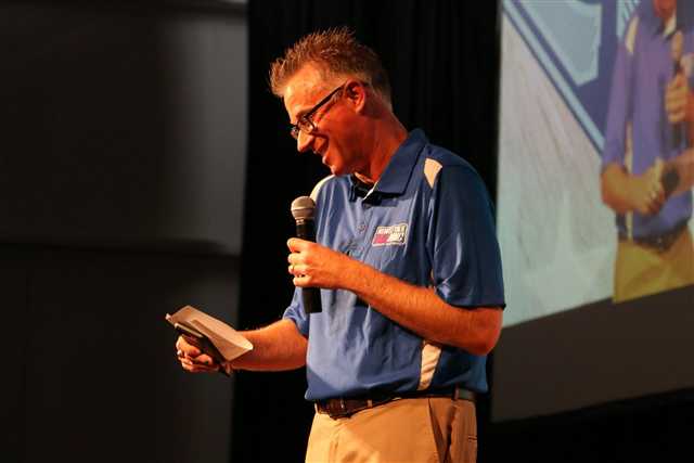 Station host on stage with a microphone